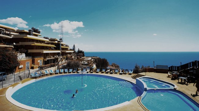 Piscina circolare con vista mare.