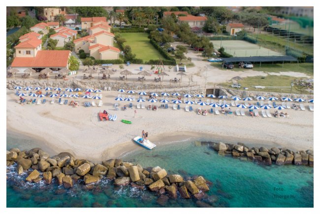 Vista aerea di spiaggia e complesso turistico.