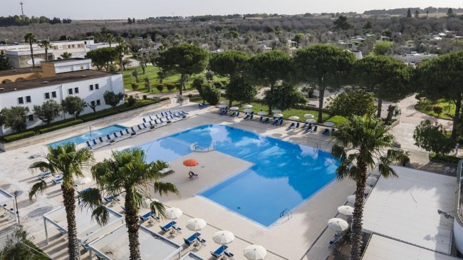 Piscina con lettini e ombrelloni; vista dall'alto.