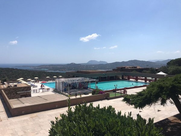 Piscina con vista panoramica sulla costa e colline.