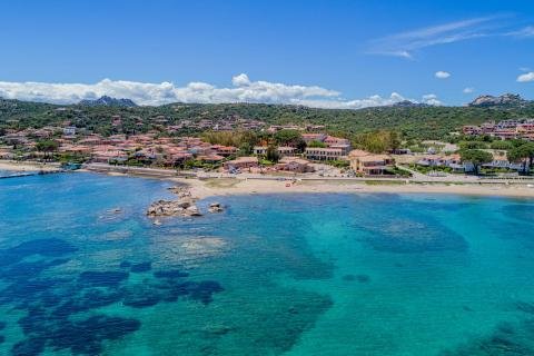 Spiaggia sabbiosa con mare limpido.