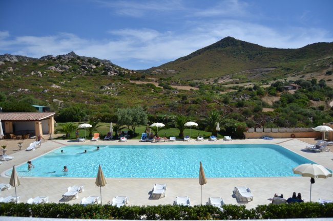 Piscina all'aperto con vista su colline verdi.