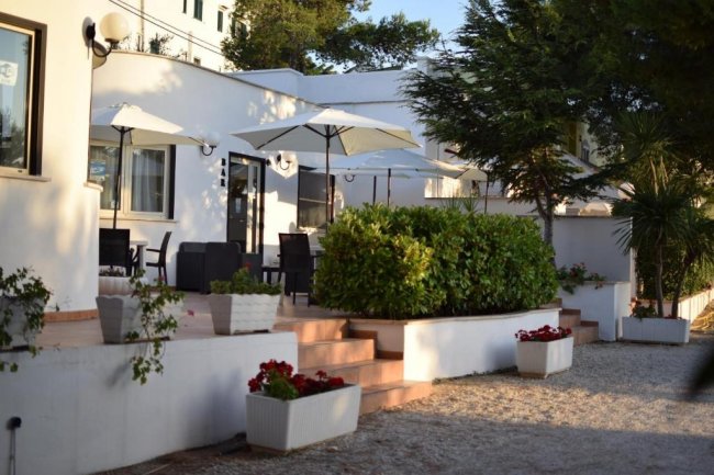 Terrazza con sedie e ombrelloni bianchi.