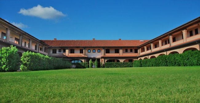 Edificio con cortile di erba e cielo blu.