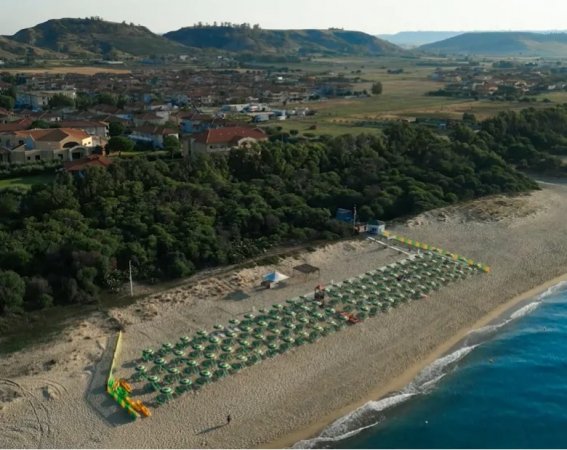 Spiaggia con ombrelloni e mare nella vista dall'alto.
