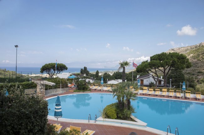 Piscina all'aperto con sedie a sdraio.