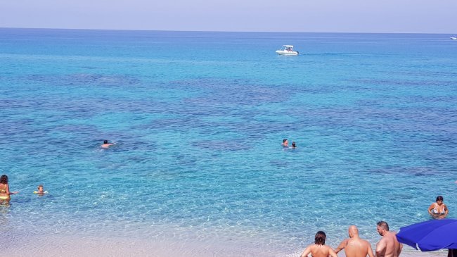 Persone che nuotano in mare cristallino.