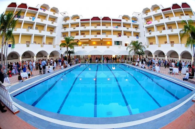 Piscina con persone attorno in un hotel.