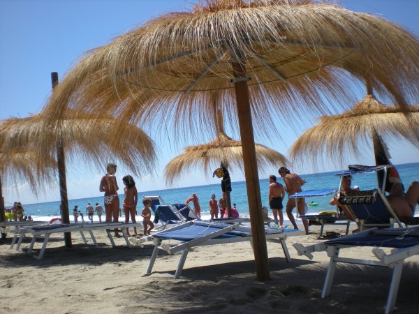 Spiaggia con ombrelloni di paglia.