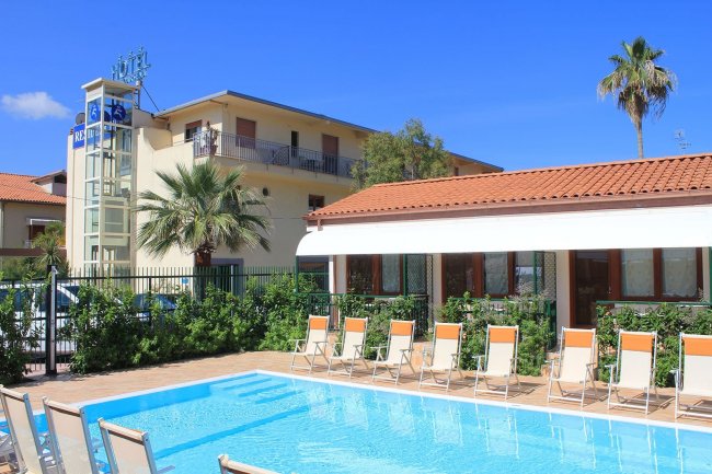 Piscina all'aperto con hotel sullo sfondo.