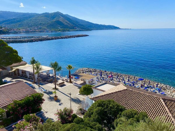 Spiaggia e mare con colline sullo sfondo.