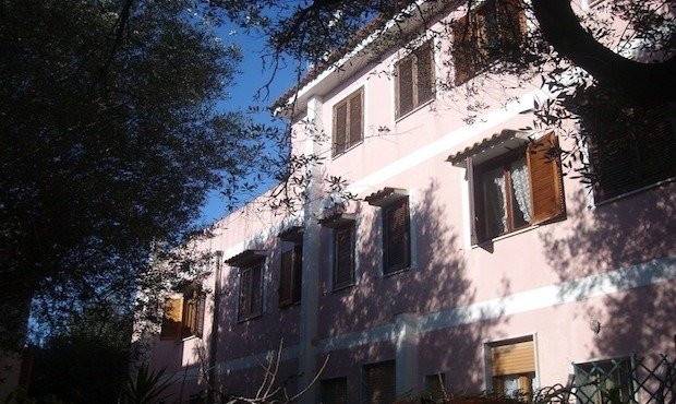 Edificio rosa tra gli alberi.