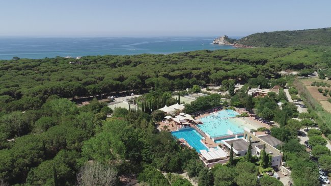 Vista aerea di un complesso con piscina e mare.