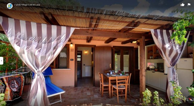 Veranda con tavolo, sedie e sdraio blu.