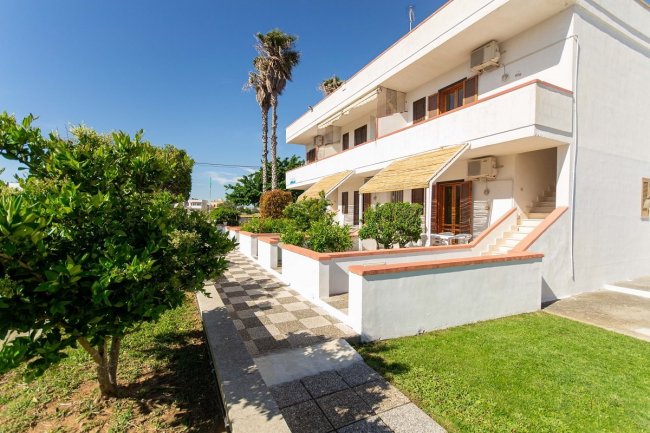 Appartamenti bianchi a due piani con giardino.