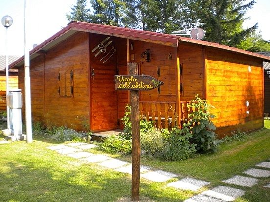 Una casetta di legno con un'insegna e vialetto di pietre.