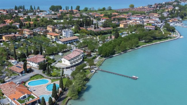 Vista aerea di un villaggio sul lago con piscina.
