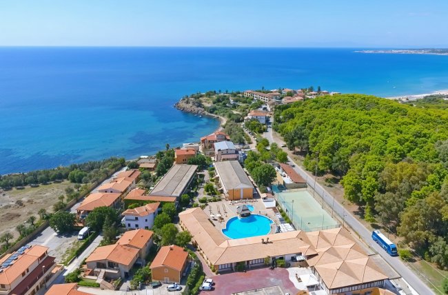 Vista aerea di un complesso con piscina, vicino al mare.