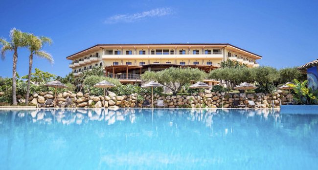 Hotel di lusso con piscina e palme.