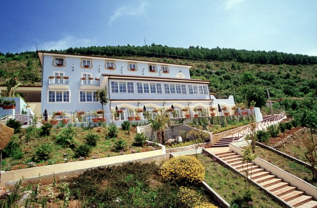 Edificio bianco su una collina verde.