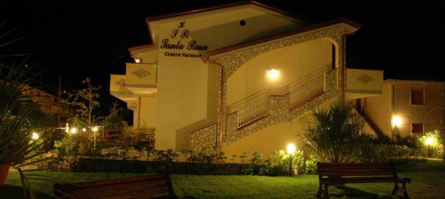 Edificio illuminato di notte con giardino.