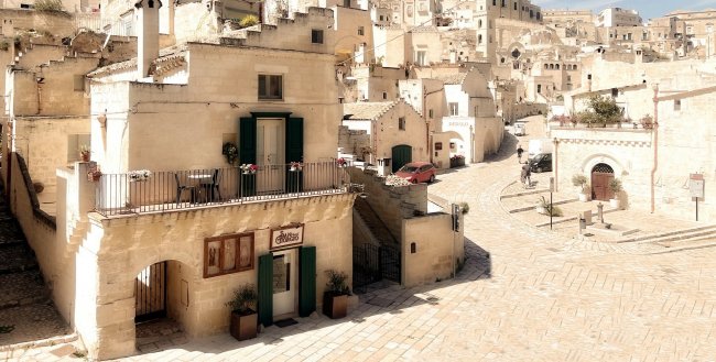 Veduta di un borgo antico con edifici in pietra e una piazza.