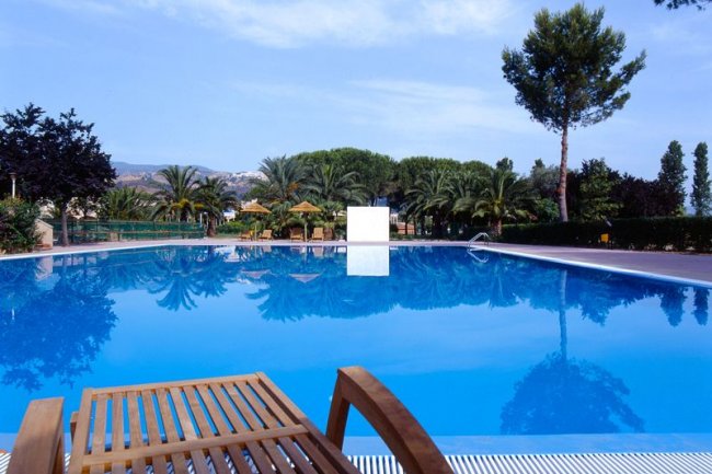 Piscina blu con lettino in legno.