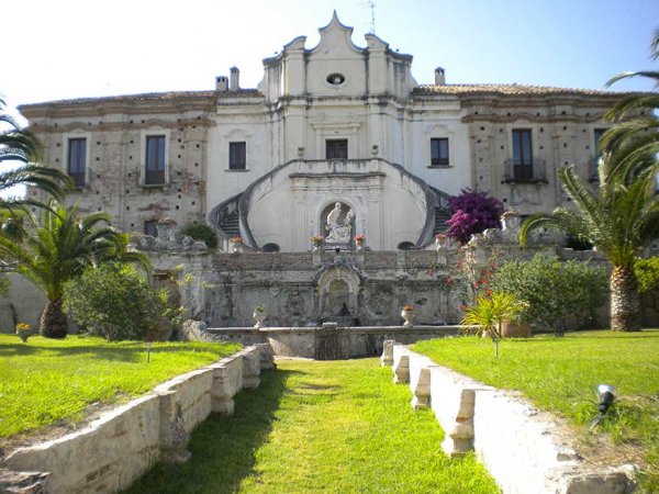 Villa storica con giardino e scalinata.