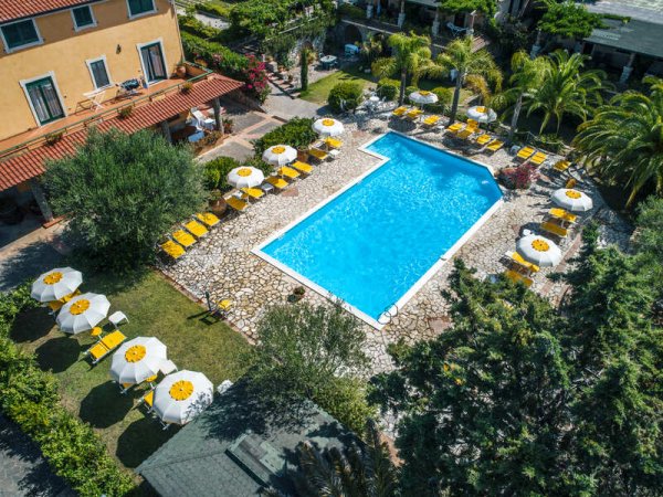 Piscina circondata da lettini e ombrelloni.