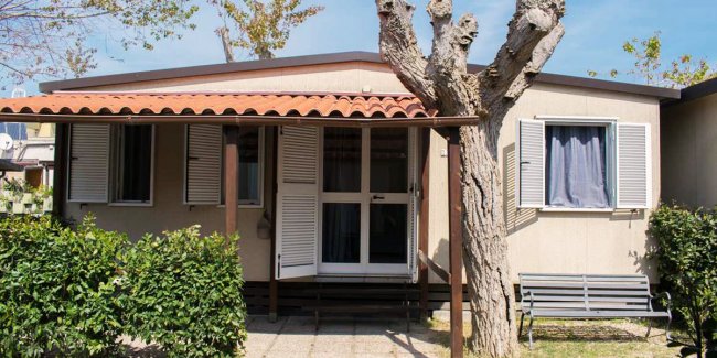 Piccola casa con tetto rosso e finestre bianche.