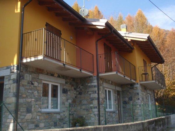 Edificio in pietra e intonaco giallo con balconi.