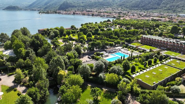 Vista aerea di una località turistica con piscine e verde.