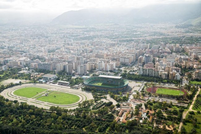 Vista aerea di una città con stadi e parchi.
