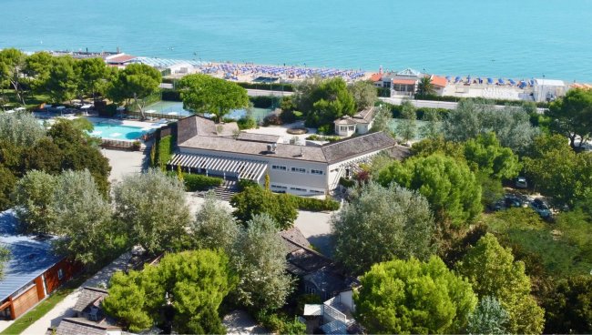 Veduta aerea di un resort con piscina e spiaggia.