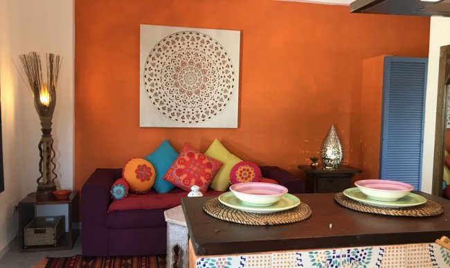 Interno colorato con divano viola e cuscini vivaci.