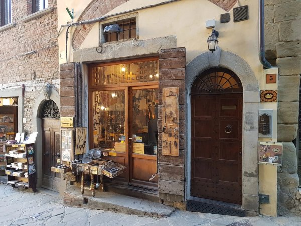 Facciata di negozio con porta in legno e vetrina illuminata.