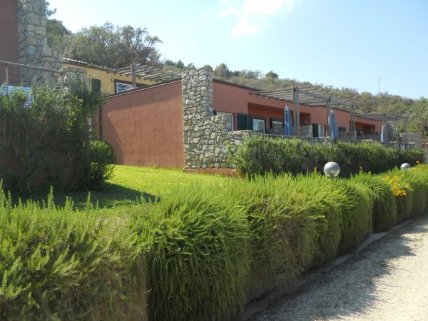 Edificio con pareti di pietra e giardino verde.