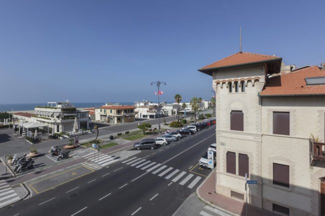 Strada con incrocio, edifici e vista mare all'orizzonte.