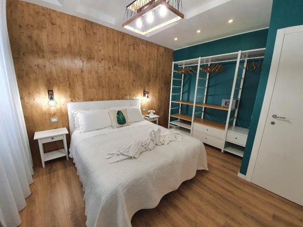 Camera con letto matrimoniale e parete in legno.