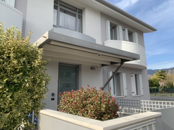 Casa moderna bianca con terrazzo e pianta.