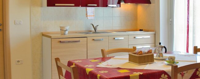 Cucina luminosa con tavolo apparecchiato.