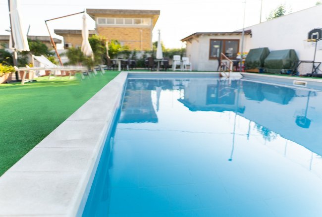 Piscina con area verde circostante.