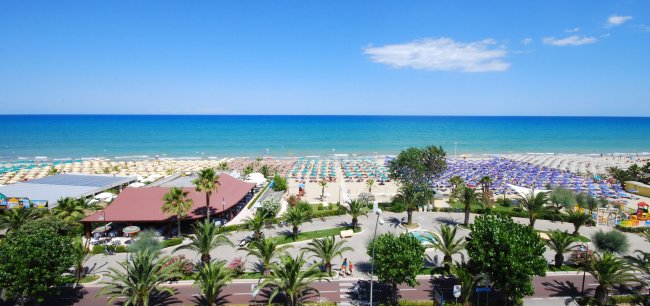 Spiaggia affollata con ombrelloni colorati.