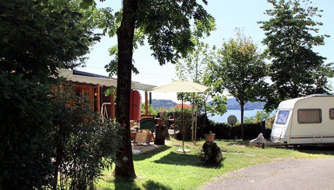 Roulotte vicino a uno spazio verde e alberi.