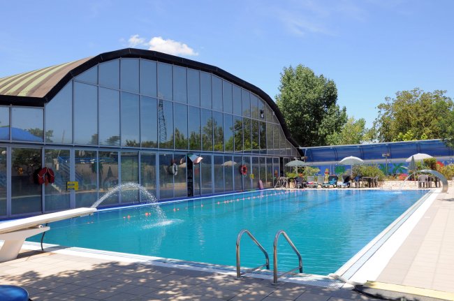 Piscina all'aperto con copertura vetrata.
