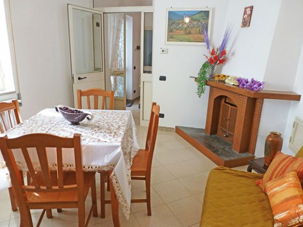 Sala da pranzo con tavolo e camino decorato.