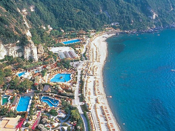 Spiaggia affollata con lettini e ombrelloni, vista dall'alto.