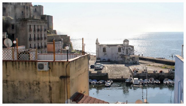 Vista su un porto con edifici e mare.