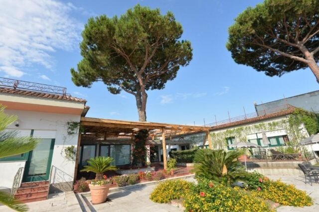 Giardino con alberi e pergola di legno.
