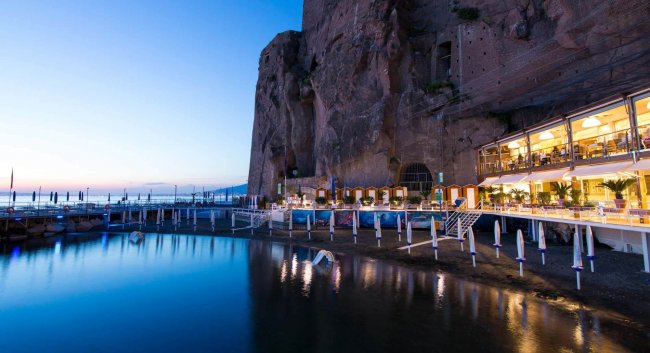 Edificio ristorante vicino alla costa rocciosa al crepuscolo.